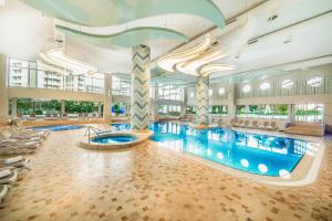a large swimming pool in a building with a swimming pool at Titanic Deluxe Lara in Lara