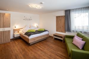 sypialnia z łóżkiem i kanapą w obiekcie Eiblhof w Schladming