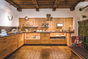 a large kitchen with wooden cabinets and a bench at Gasthaus Obergaisberg in Kirchberg in Tirol