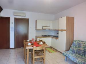 a living room with a table and a kitchen at Residence Leopardi - Gemini in Bibione
