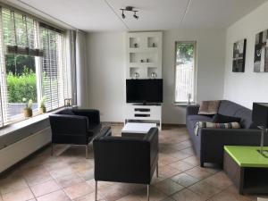 een woonkamer met een bank en een tv bij 't Hulzen 55 or 61 Winterswijk in Winterswijk