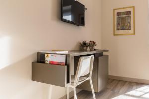 a desk with a white chair in a room at parina Inn – Locanda in Camerata Cornello