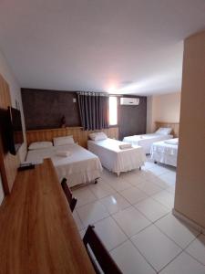 Habitación de hotel con 2 camas y mesa en Borges Hotel, en Imperatriz