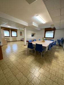 a large room with a table and blue chairs at Casa Vacanze Paolo VI in Padova