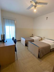 a room with two beds and a desk and a tv at Casa Vacanze Paolo VI in Padova