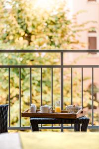 a table on a balcony with cups and drinks at Hôtel Hélios in Juan-les-Pins