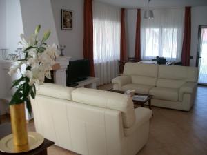 sala de estar con 2 sofás blancos y TV en Pensiunea Funivia, en Săcele