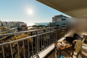 a balcony with a table and a view of the ocean at Hôtel Hélios in Juan-les-Pins