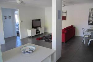 ein Wohnzimmer mit einem roten Sofa und einem TV in der Unterkunft Cronulla Beach Elanora Gardens in Cronulla