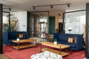 a living room with blue couches and tables at Shada Hotel Shatea in Jeddah +42 photos