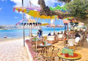a group of people sitting at tables under umbrellas on the beach at Ático a 200m del mar. in Jávea
