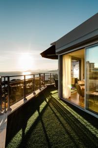 a house with a balcony with a view of the ocean at Hôtel Hélios in Juan-les-Pins