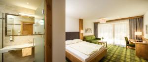 una camera d'albergo con un letto e un bagno di Hotel Alphof Alpbach ad Alpbach