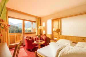 una camera d'albergo con un letto e una grande finestra di Hotel Alphof Alpbach ad Alpbach