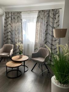 uma sala de estar com duas cadeiras, uma mesa e uma janela em SOLE Apartment 1 em Satu Mare