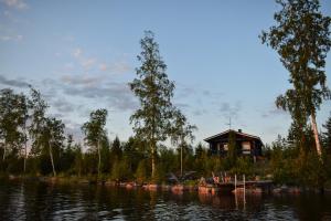 a cabin on the shore of a lake with a house at Loma-Autio Apaja in Puumala
