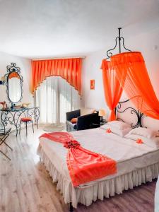 a bedroom with a large bed with an orange canopy at Familly Art Hotel Nirvana in Shumen