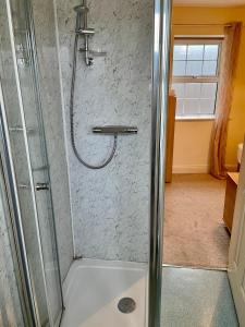 a shower with a glass door in a bathroom at An Stór Townhouse in Midleton