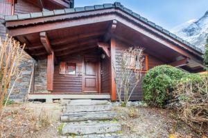 een huis met een houten deur en een trap aan de voorkant bij Le Hameau des Neiges in Les Trabets +9 foto's