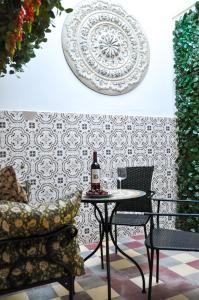 a table with a bottle of wine and a chair at Casa Salinas, Elegant Flat w patio in Taviras Historical Centre in Tavira