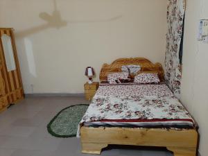 a bedroom with a wooden bed in a room at Appartement chambre salon climatisées, cuisine in Bamako