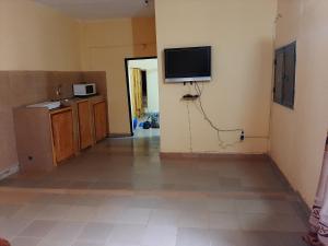 uma sala de estar com televisão na parede em Appartement chambre salon climatisées, cuisine em Bamako