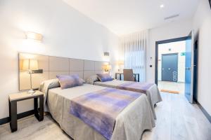 een hotelkamer met 2 bedden en een tafel bij HOTEL IBERUM in Illescas
