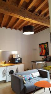 a living room with a blue couch and a kitchen at Appartement Roquette Serenity in Arles