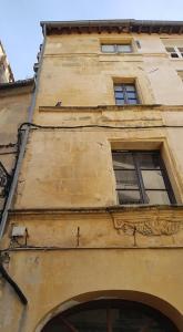 a tall building with two windows on the side of it at Appartement Roquette Serenity in Arles
