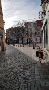 una bicicleta estacionada en una calle empedrada en Appartement Roquette Serenity en Arlés