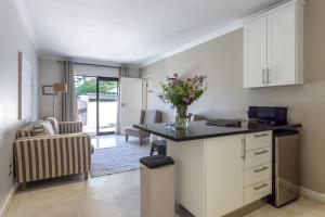 een keuken met een bureau en een vaas met bloemen bij Wedgeview Country House & Spa in Stellenbosch