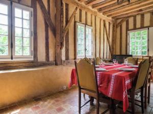 una sala da pranzo con tavolo, sedie e finestre di Holiday home with private terrace a Saint-Aignan