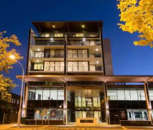 a tall building with glass windows at night at The Botanical 301 in Albury