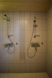a shower in a bathroom with two faucets at Loma-Autio Tähti Villa in Puumala