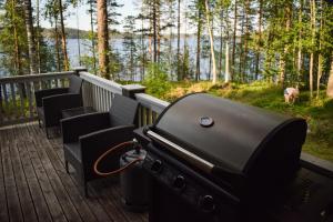 a grill on a deck with a view of a lake at Loma-Autio Tähti Villa in Puumala