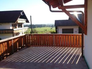 une terrasse en bois avec vue sur une maison dans l'établissement Cosy holiday home with sauna in the Allg u, à Burggen