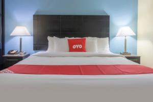 Una cama grande con una almohada roja. en OYO Hotel Knoxville TN Cedar Bluff I-40 en Knoxville