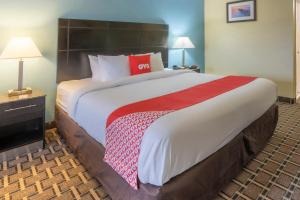 a large bed in a hotel room with a red pillow at OYO Hotel Knoxville TN Cedar Bluff I-40 in Knoxville
