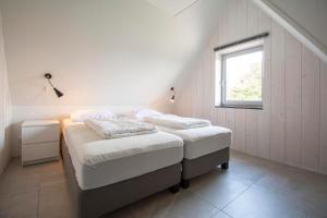 a bedroom with two beds and a window at Sandepark 171 - Groote Keeten in Callantsoog