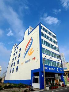 a large white and blue building with a sign on it at Hermit Crab B&B in Wuqi