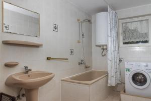 a bathroom with a sink and a washing machine at Familia Nyaraló 117 in Balatonmáriafürdő