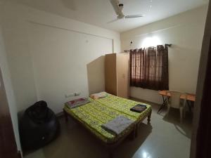 um pequeno quarto com uma cama e um frigorífico em Professionals Pride PG em Bangalore