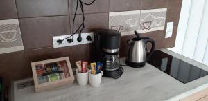 un comptoir avec une cafetière et des tasses dessus dans l'établissement Riviéra Wellness Apartman, à Siófok