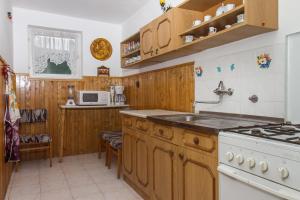 バラトンマーリアフュルドゥーにあるFamilia Nyaraló 117のキッチン(木製キャビネット、白いコンロ付)
