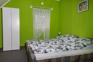バラトンマーリアフュルドゥーにあるFamilia Nyaraló 117の緑のベッドルーム(ベッド1台、窓付)