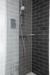 a bathroom with a shower with black tiles at Holiday Inn Express Amsterdam - North Riverside by IHG in Amsterdam