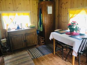 uma cozinha com uma mesa com um vaso de flores em Tiny hut in the forest overlooking the river em Avesta
