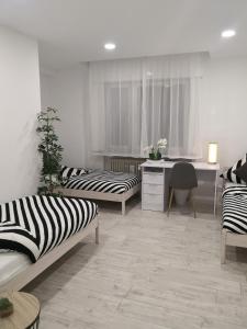 a room with two beds and a desk and a table at Schöne, renovierte und optimal gelegene Wohnung in Weißkirchen