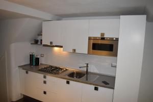 ヴェルナッツァにあるSilver Flatの白いキャビネット、シンク、電子レンジ付きのキッチンが備わります。