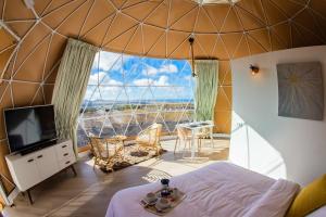 una habitación con una cama y una ventana grande en Eslanzarote Luxurious Eco Dome Experience, en Teguise
